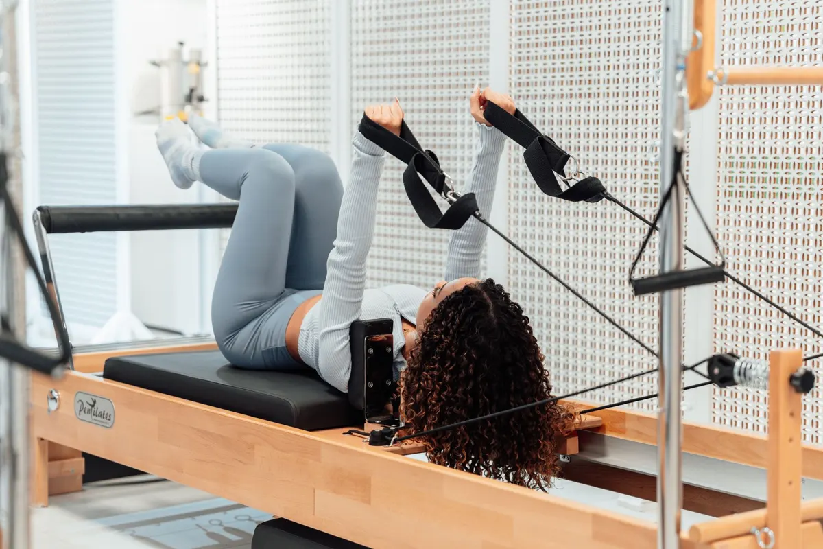 Client on the Reformer in the straps