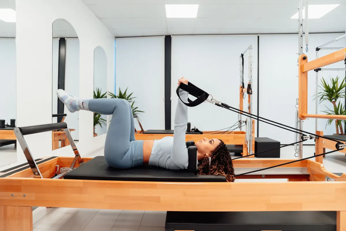 Client on the Reformer with her feet in the straps